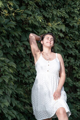 Young beautiful smiling woman in Virginia creeper in spring