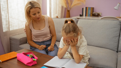 Mother and daughter sitting together in a cozy living room, with the child appearing upset while the woman offers comfort.