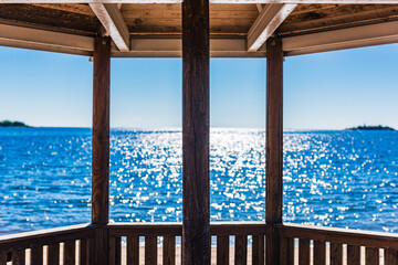View of Lake Vanern in Sweden showcasing shimmering water under a clear blue sky from a sheltered viewpoint