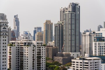 Obraz premium Urban skyline with modern skyscrapers and residential buildings in a bustling city center during daylight hours