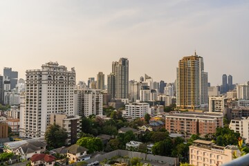 City skyline of Bangkok showcasing a blend of modern skyscrapers and traditional buildings during late afternoon light