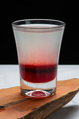 Drinks alcóolicos a base de bebidas destilada servidos sobre pedra de mármore e fundo preto.
