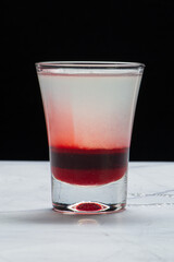 Drinks alcóolicos a base de bebidas destilada servidos sobre pedra de mármore e fundo preto.
