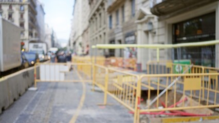 Blurred street with construction barriers on a busy day in barcelona, spain featuring unfocused pedestrians and vehicles lining the european cityscape.