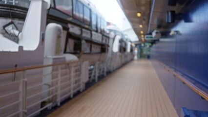 Blurred cruise deck photo featuring lifeboats, rails, and distant figures, evoking a sense of travel and exploration, with a focus on maritime safety and relaxation.