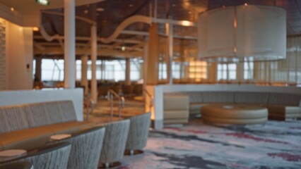 Defocused luxury restaurant with bokeh lights, showcasing elegant indoor seating and ambient lighting, creating an upscale dining atmosphere.