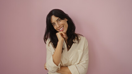 Young woman smiling over isolated pink background displaying an attractive and confident look