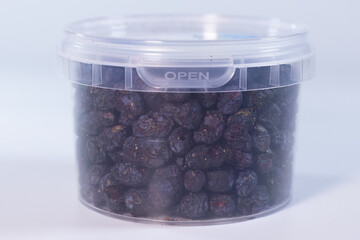 A clear plastic container filled with freeze-dried blueberries, preserving their natural shape, vibrant blue color, and crisp texture. Perfect for snacks or baking.
