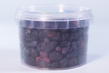 A clear plastic container filled with freeze-dried blueberries, preserving their natural shape, vibrant blue color, and crisp texture. Perfect for snacks or baking.