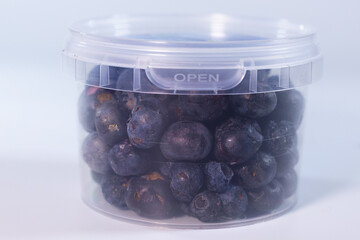 A clear plastic container filled with freeze-dried blueberries, preserving their natural shape, vibrant blue color, and crisp texture. Perfect for snacks or baking.