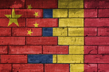 colourful painted big flag of china and flag of romania on a massive old brick wall background....
