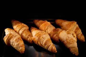 Homemade croissants baking in oven , close-up