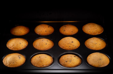 Tasty Homemade muffins baking in oven , close-up