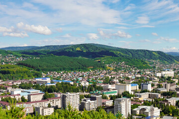 Obraz premium Birds eye view of beautiful urban landscape on a sunny day, with mountains and forests and lots of clouds against the background