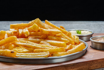 Porção de batatas fritas, servida com molho rosê e maionese