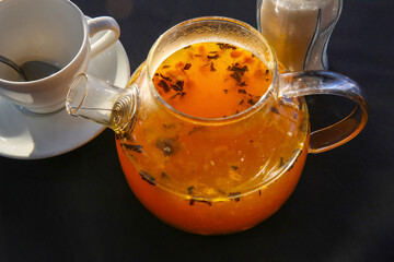 Hot fruit tea (with citruses and sea buckthorn) brewed in a glass teapot