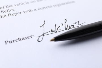 Signature and pen on paperwork, closeup view