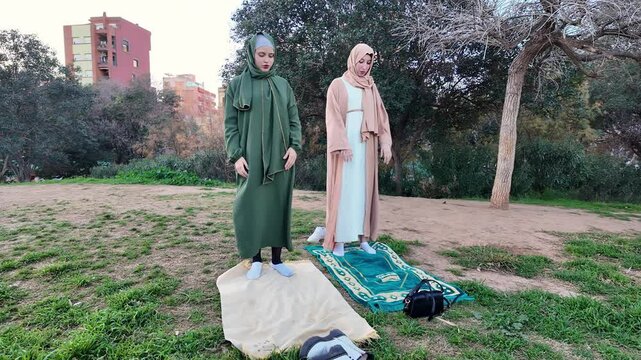 Muslim women praying outdoors in a park
