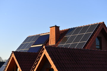 Fototapeta premium Solar system and hot water booster on a house roof in a housing estate, renewable energies