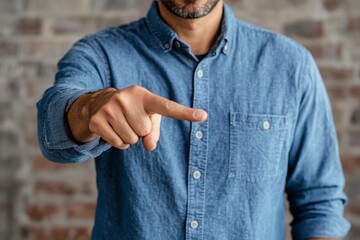 Man gesturing with pointing finger against a rustic brick wall in a casual setting