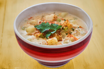 bowl of New England clam chowder topped with fresh parsley