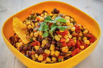 corn and black bean salsa served in a yellow bowl