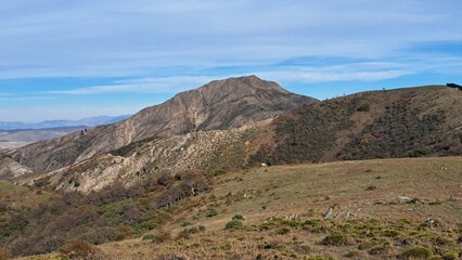 Whispers of the Wild Hills. Rugged mountain landscapes meet serene pastures, where untamed beauty unfolds in perfect harmony with nature's raw spirit.