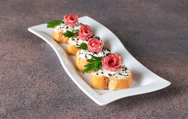 Canapes with cream cheese and sausage on bread toast