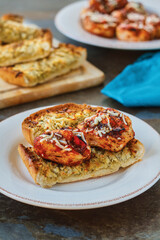marinated grilled chicken pieces on garlic bread toast points