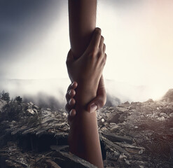 A helping hand extends from the ruins of a building destroyed by an earthquake