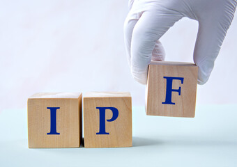 Cubes with the abbreviation IPF in the hand of a doctor.