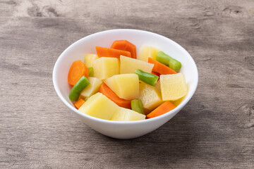 Cooked vegetables in a bowl over wooden table