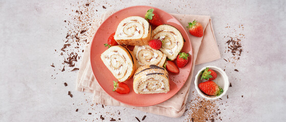 Pink plate with pieces of delicious sponge cake roll, fresh strawberries, napkin and chocolate on light background