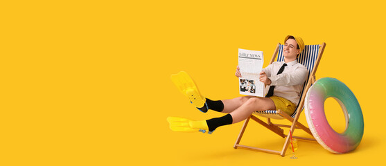 Office worker with inflatable ring and flippers sitting on deck chair and reading newspapers on yellow background © Pixel-Shot