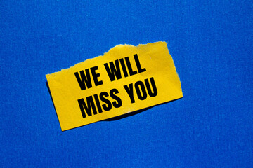 We will miss you message written on ripped torn yellow paper piece with bluebackground. Conceptual we will miss you symbol. Copy space.
