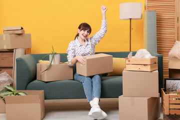 Happy woman with moving boxes in new apartment. Housewarming party