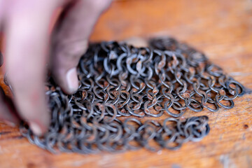 A hand is touching a chain of metal rings