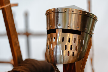 A knight's helmet with a metal face plate and a strap