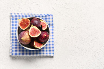 Bowl with ripe fresh figs on textured white background