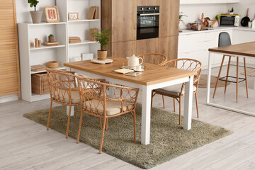 Interior of cozy kitchen with dining table and shelf units