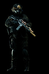 Tactical soldier in dark uniform with advanced equipment and rifle