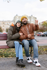 Obraz premium Happy couple enjoying autumn day on park bench, sharing stories and laughter