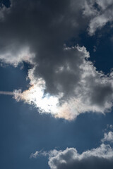 photo Spectacular Celestial Phenomenon: Sunlight Piercing Through Dark Clouds in a Vibrant Blue Sky Creating a Contemporary Natural Masterpiece