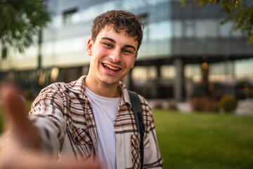 Self portrait or video call of beautiful welcoming young man stand