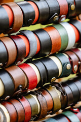 A row of leather bracelets are displayed in a store
