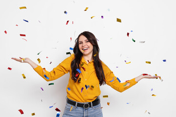 Fototapeta premium Happy woman under falling confetti on white background. Surprise party