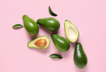 Fresh ripe avocados and leaves on pink background