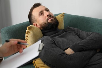 Fototapeta premium Psychologist working with patient during hypnosis session indoors, closeup