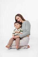 Happy mother with her cute little son on white background