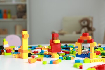 Construction toy. Colorful building blocks on white table indoors, closeup